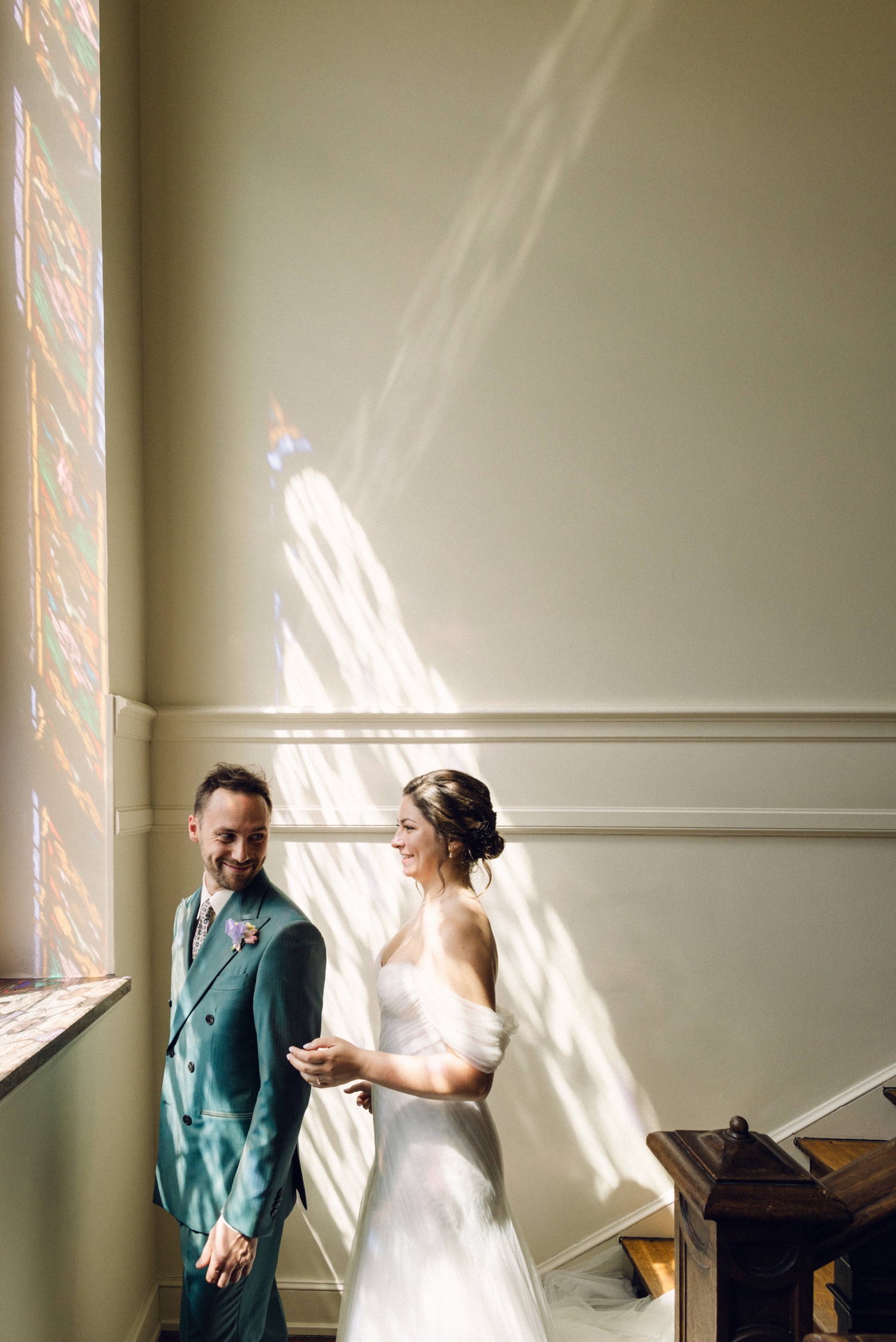 regard complice des mariés dans un escalier lumineux