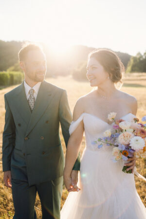 couple de mariés en contre-jour au coucher du soleil dans un jardin